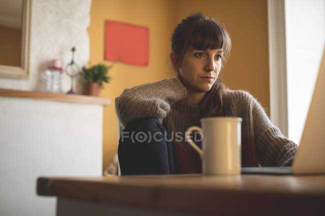 Femme utilisant un ordinateur portable à la maison — Photo de stock