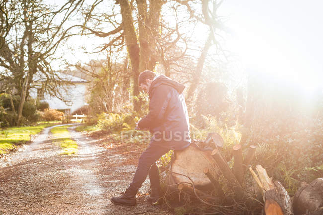 Homem relaxante no tronco de madeira — Fotografia de Stock