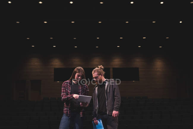 Male actor and female actress reading script on stage at theatre. — Stock Photo