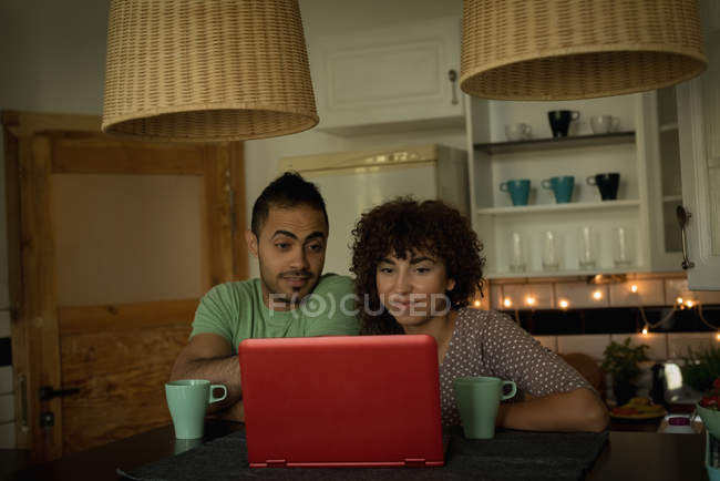 Paar benutzt Laptop beim Kaffee zu Hause — Stockfoto