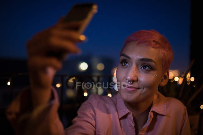 Stylish woman taking selfie with mobile phone indoors. — Stock Photo