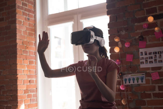 Esecutivo femminile utilizzando cuffie realtà virtuale in ufficio — Foto stock