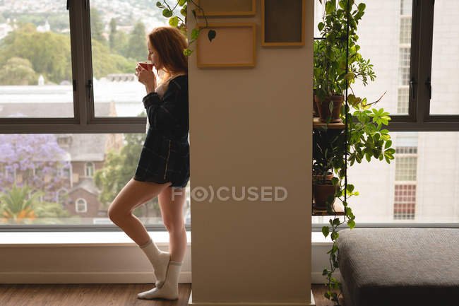 Vue latérale de la femme prenant un café à la maison — Photo de stock