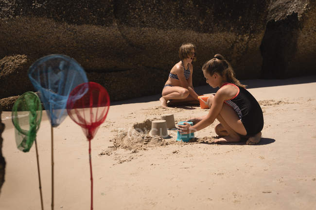 Блудниці грають в пісок на пляжі в сонячний день — стокове фото