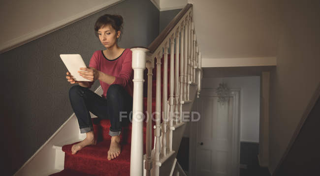 Frau nutzt digitales Tablet im Treppenhaus zu Hause — Stockfoto