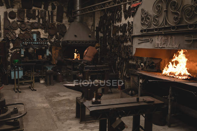 Rückansicht der Schmiede bei der Arbeit in der Werkstatt — Stockfoto