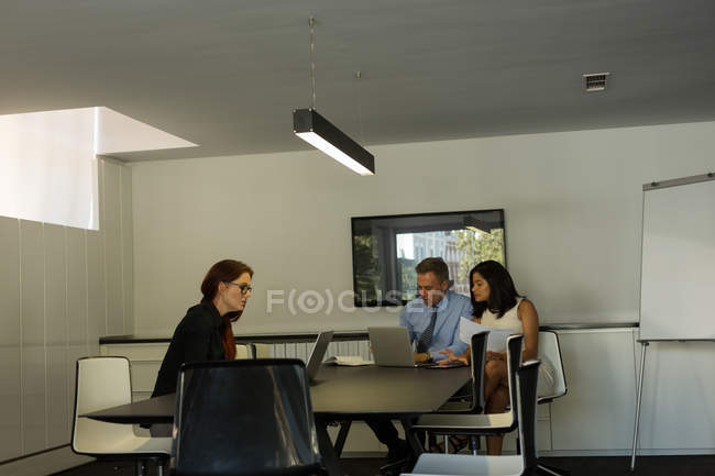 Los colegas de negocios que trabajan en el ordenador portátil en la sala de conferencias en casa - foto de stock