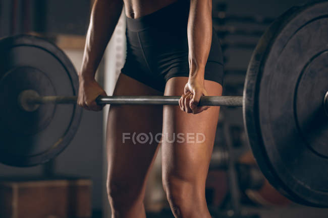 Mujer en forma levantando la barra en el gimnasio - foto de stock