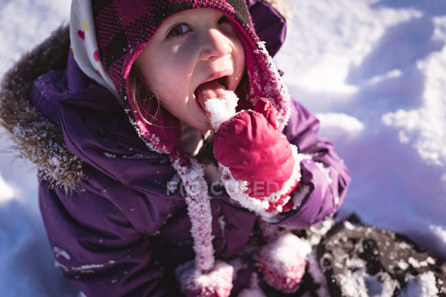 Retrato de menina bonito lambendo neve durante o inverno — Fotografia de Stock