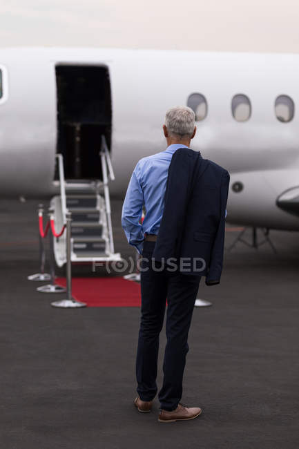 Vista posteriore di uomo d'affari dai capelli grigi in piedi sulla pista — Foto stock