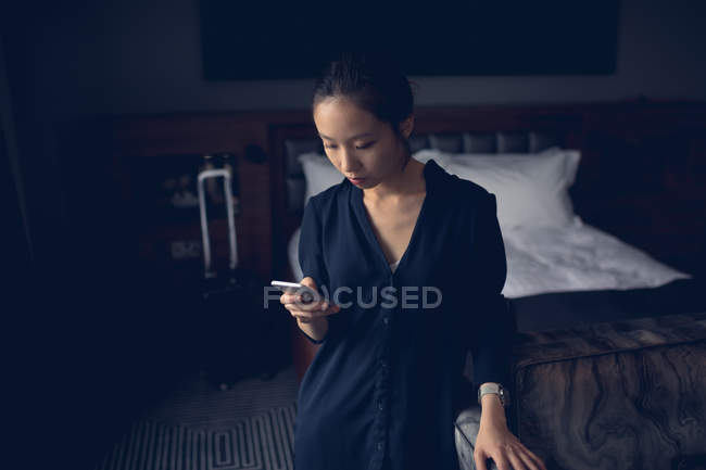 Mulher usando telefone celular no quarto de hotel — Fotografia de Stock