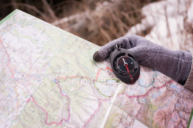 Close-up of woman hand holding compass and map — Stock Photo