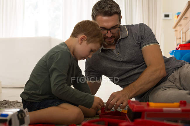 Pai e filho brincando juntos na sala de estar em casa — Fotografia de Stock