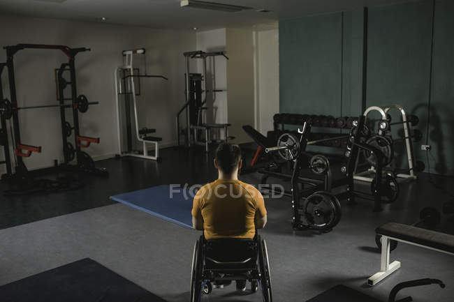 Вид ззаду інвалідний чоловік розслабляється на інвалідному візку в тренажерному залі — стокове фото