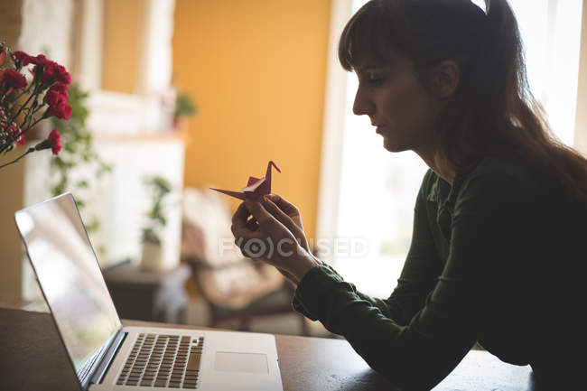 Женщина с ноутбуком готовит бумажные изделия дома — стоковое фото