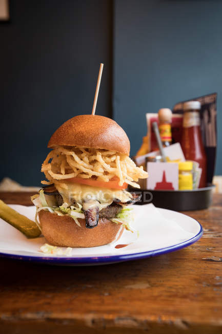 Gros plan d'un hamburger servi dans une assiette au restaurant . — Photo de stock