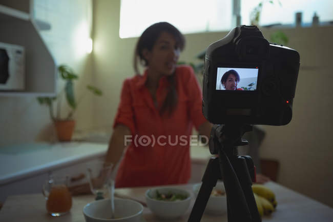Mujer video blogger grabación vlog en cocina en casa - foto de stock