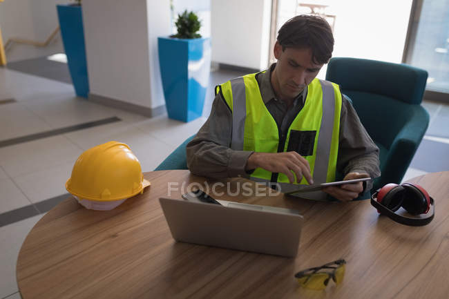 Работник мужского пола с помощью цифрового планшета на столе в офисе — стоковое фото
