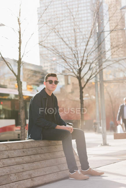 Homme réfléchi assis près du côté de la rue — Photo de stock