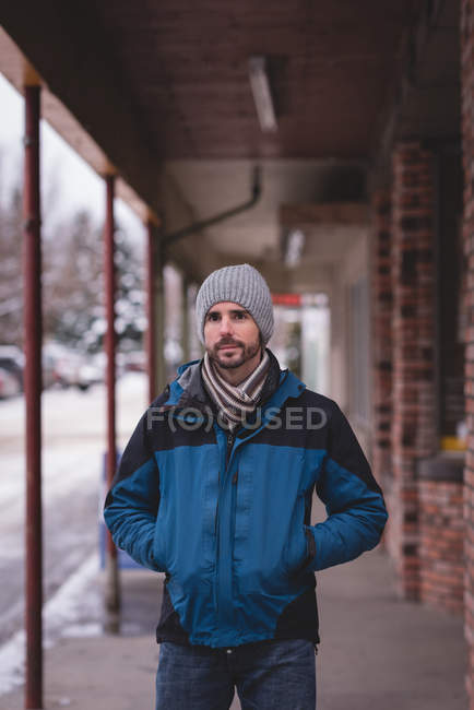Portrait of man standing with hands in pockets on sidewalk. — Stock Photo
