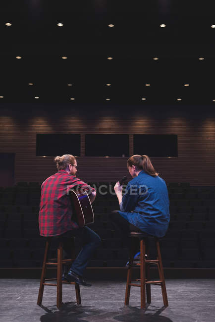 Singer and musician performing on stage at theatre. — Stock Photo