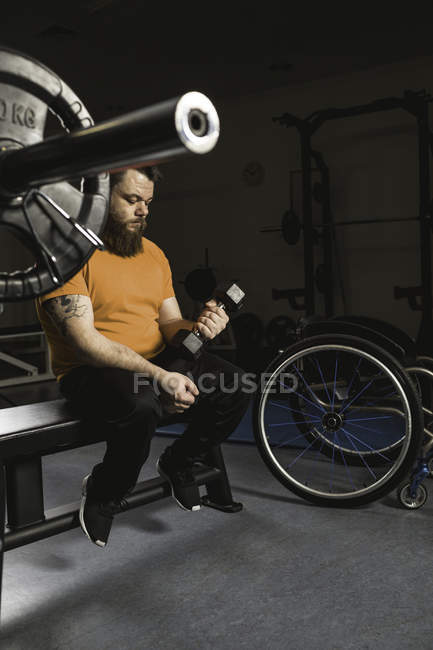 Інвалідний чоловік займається з гантелі в спортзалі — стокове фото