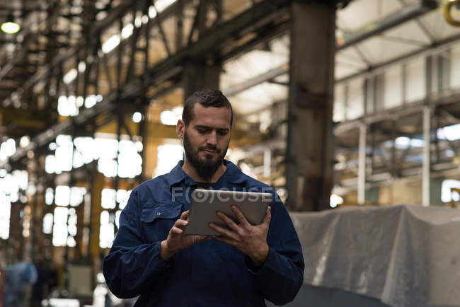 Técnico que utiliza tableta digital en la industria del metal - foto de stock