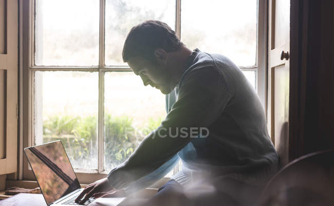 Uomo attento utilizzando il computer portatile a casa — Foto stock