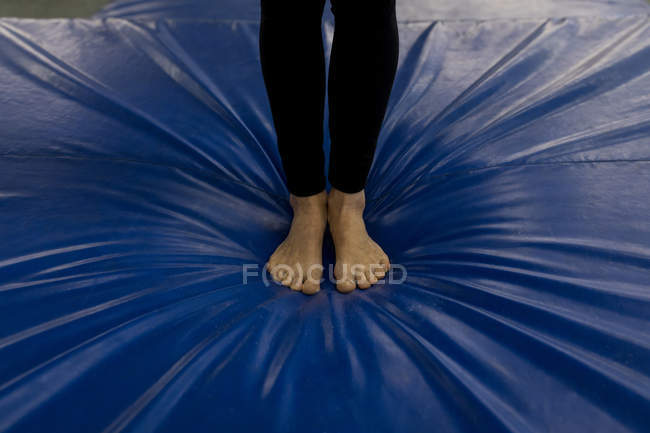 Sección baja de la deportista practicando pilates en el gimnasio - foto de stock