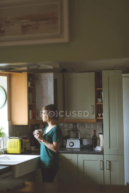 Donna premurosa che prende il caffè in cucina a casa — Foto stock