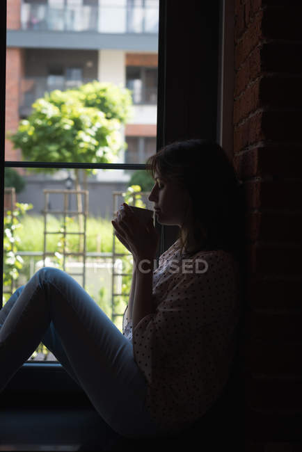 Молода жінка-виконавця має каву в офісі — стокове фото
