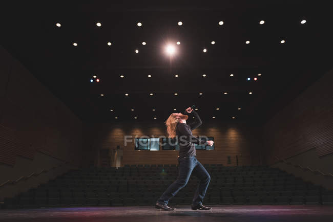 Male singer performing on stage at theatre. — Stock Photo
