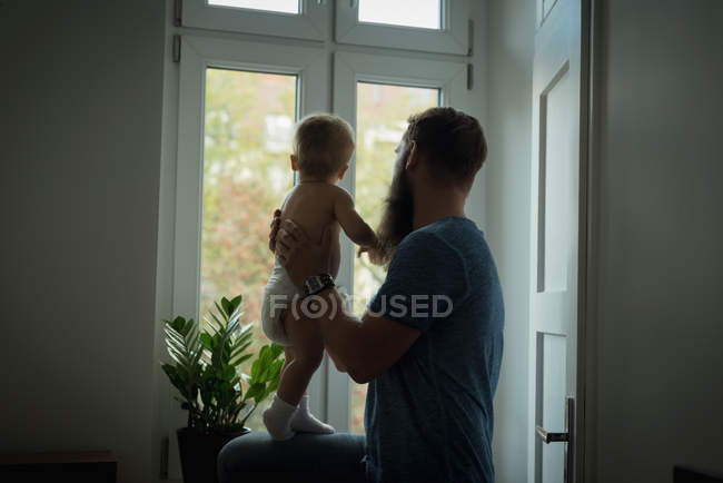 Pai segurando seu bebê em casa — Fotografia de Stock