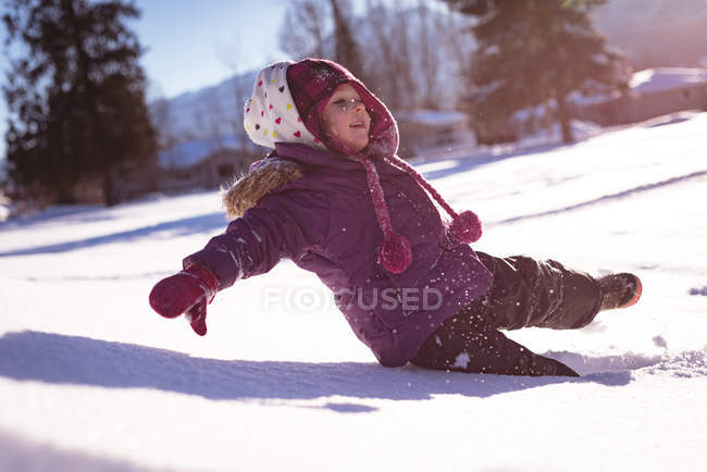 Chica despreocupada jugando en la nieve durante el invierno - foto de stock