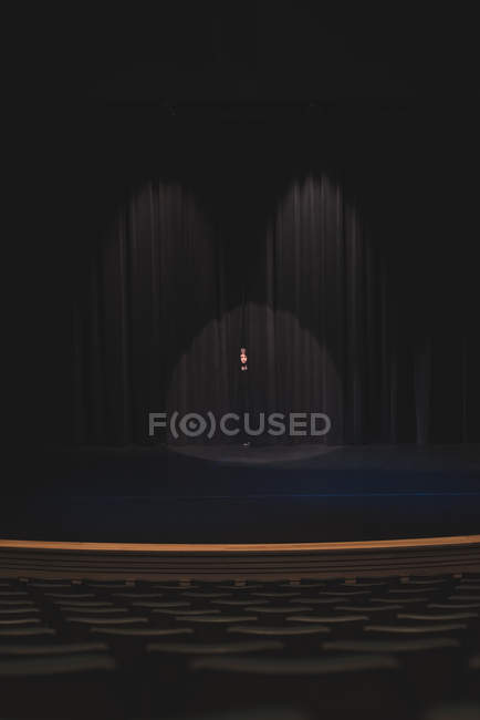 Schauspielerin steht im Theater hinter Vorhang auf der Bühne. — Stockfoto