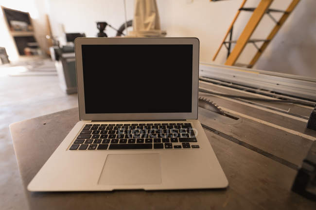 Close-up of laptop on table in industrial workshop. — Stock Photo
