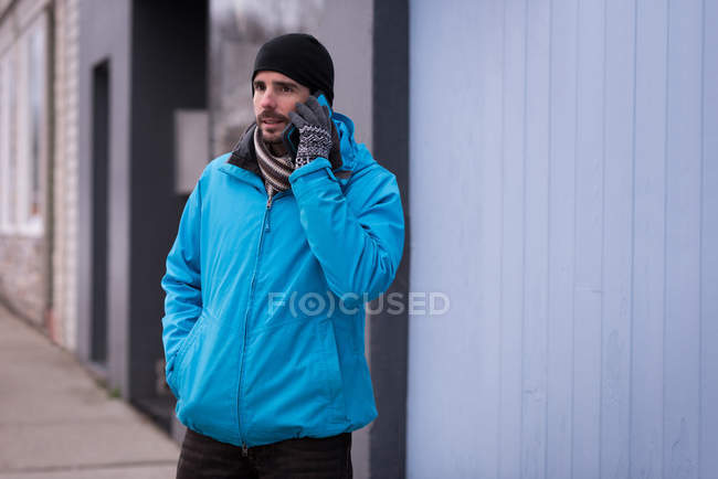 Homem falando no celular na rua da cidade durante o inverno . — Fotografia de Stock