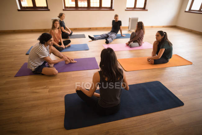 Female trainer interacting with group of people in fitness club — Stock Photo