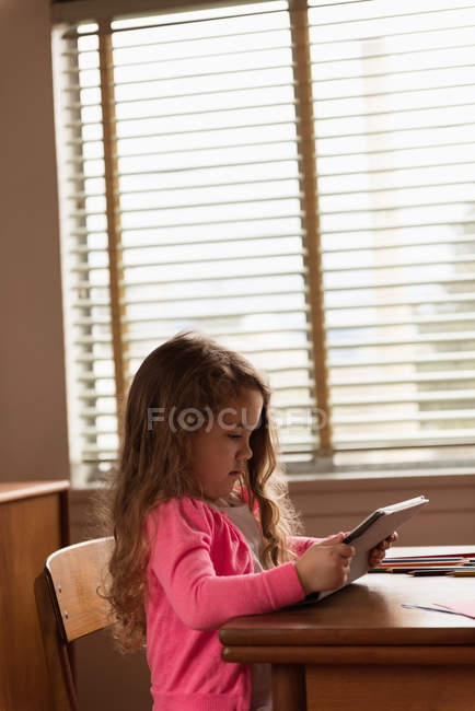 Menina bonito usando tablet digital em casa — Fotografia de Stock