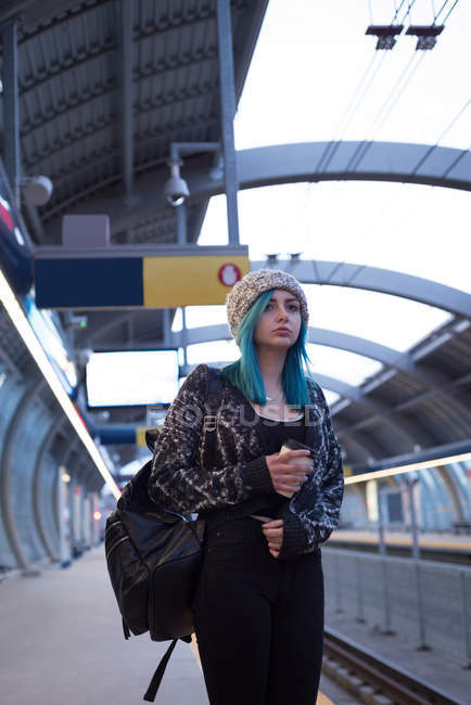 Стильна жінка чекає на поїзд на залізничній платформі — стокове фото