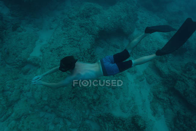 Vista aérea del hombre nadando bajo el agua en el mar - foto de stock