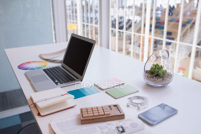 Laptop e relógio de cor na mesa no escritório — Fotografia de Stock