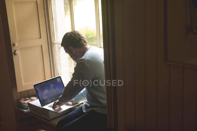 Attentive man using laptop at home — Stock Photo