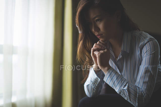 Pensativa mujer de negocios sentada en un sillón en la habitación de hotel - foto de stock