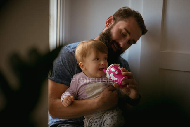 Padre alimentando a su hijo en casa - foto de stock