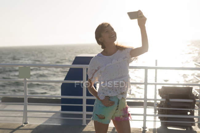 Woman taking selfie with mobile phone on cruise ship — Stock Photo