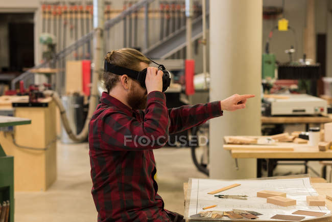 Чоловічий тесля з використанням гарнітури віртуальної реальності в майстерні — стокове фото