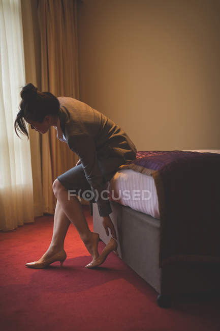 Geschäftsfrau zieht in Hotelzimmer ihre Schuhe aus — Stockfoto