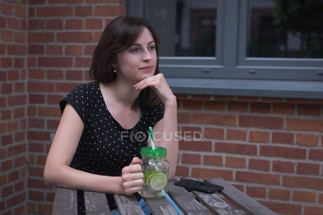 Nachdenkliche Frau trinkt im Freien — Stockfoto