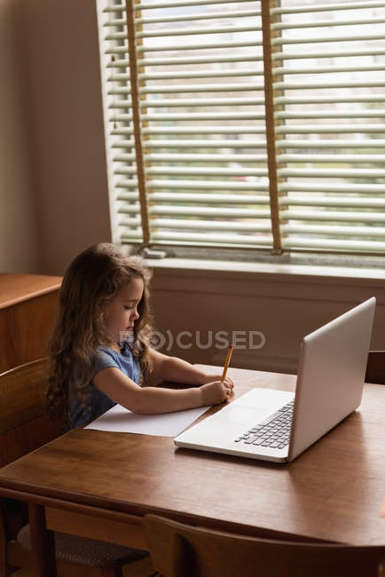 Adorable niña haciendo su tarea en casa - foto de stock